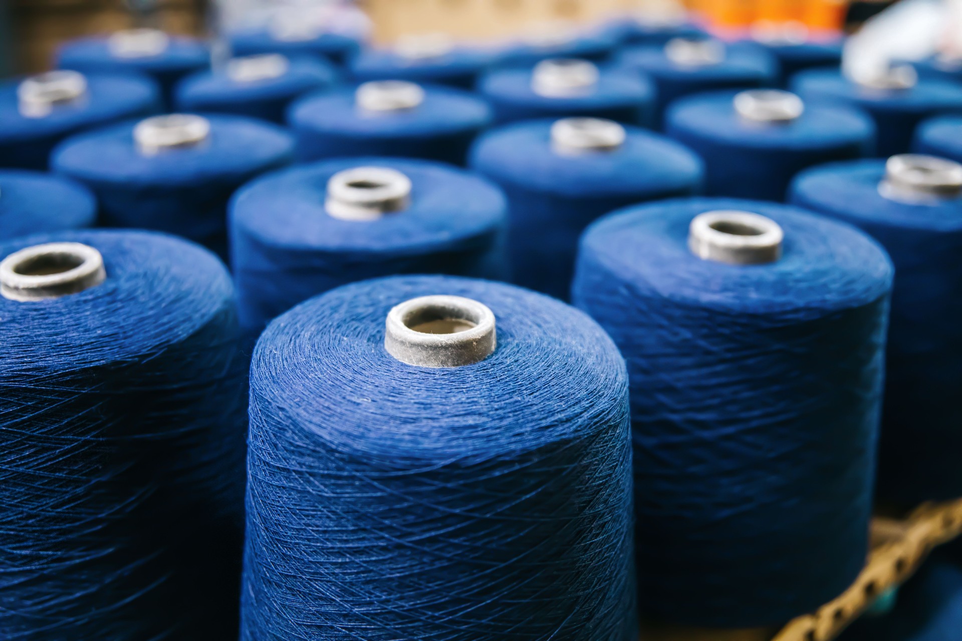 Blue Cotton yarns or threads on spool tube bobbins at cotton yarn factory.