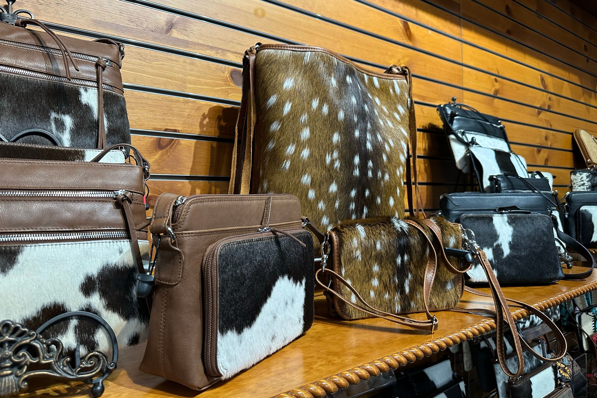 Handmade leather cowboy bags on wooden shelf in store in texas.